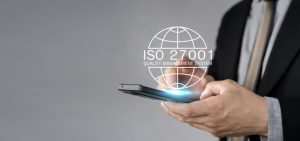 Businessman holding a tablet and showing a symbol ISO 2700
